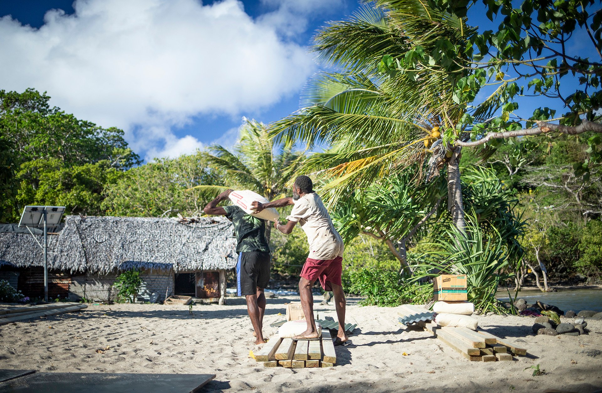 Two residents of Emao Island in Vanuatu strengthen their houses with cement to prepare for cyclones