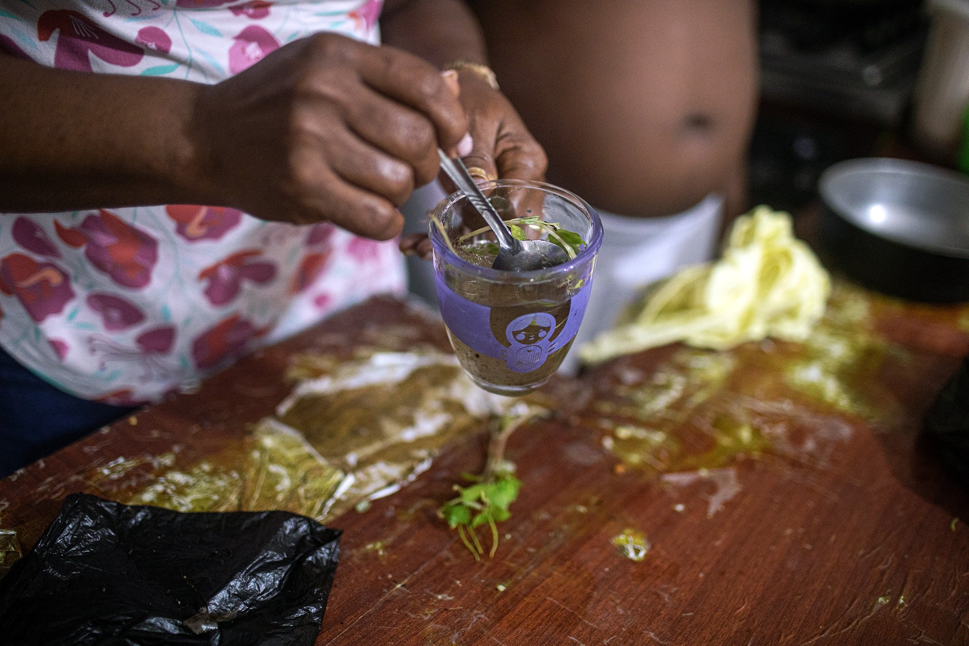 A close-up shot of a glass of brew with celandine (a medicinal plant), cinnamon, and sugar, prepared by Luz Maritza Moreno, a traditional midwife.