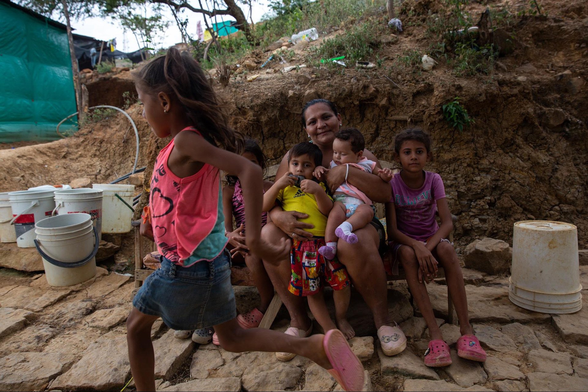 Yuri Castro, 32, sits with her children for a portrait outside their home in Alfonso Gomez