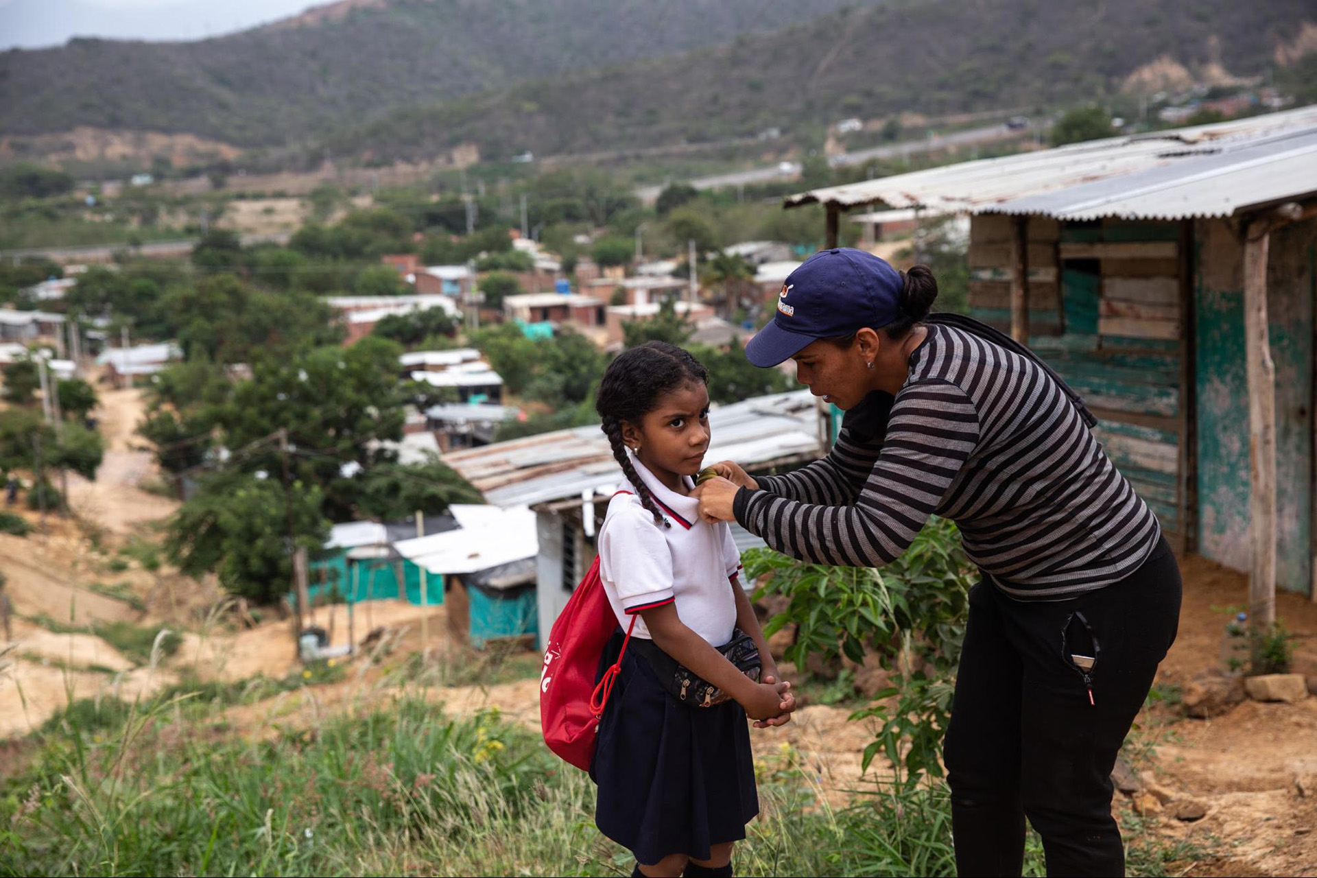 Oriana Duran adjusts the collar of her daughter Nicole Gulffo’s school uniform