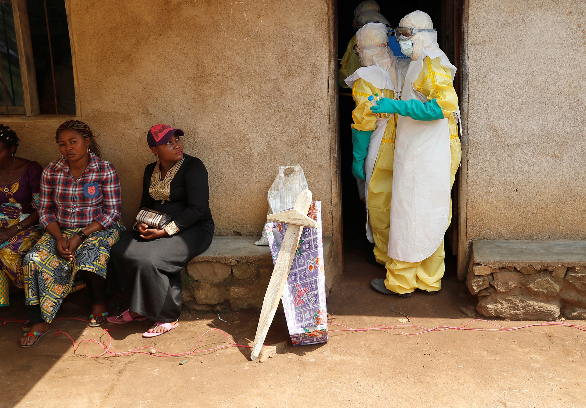 Healthcare workers in the town of Beni enter a house