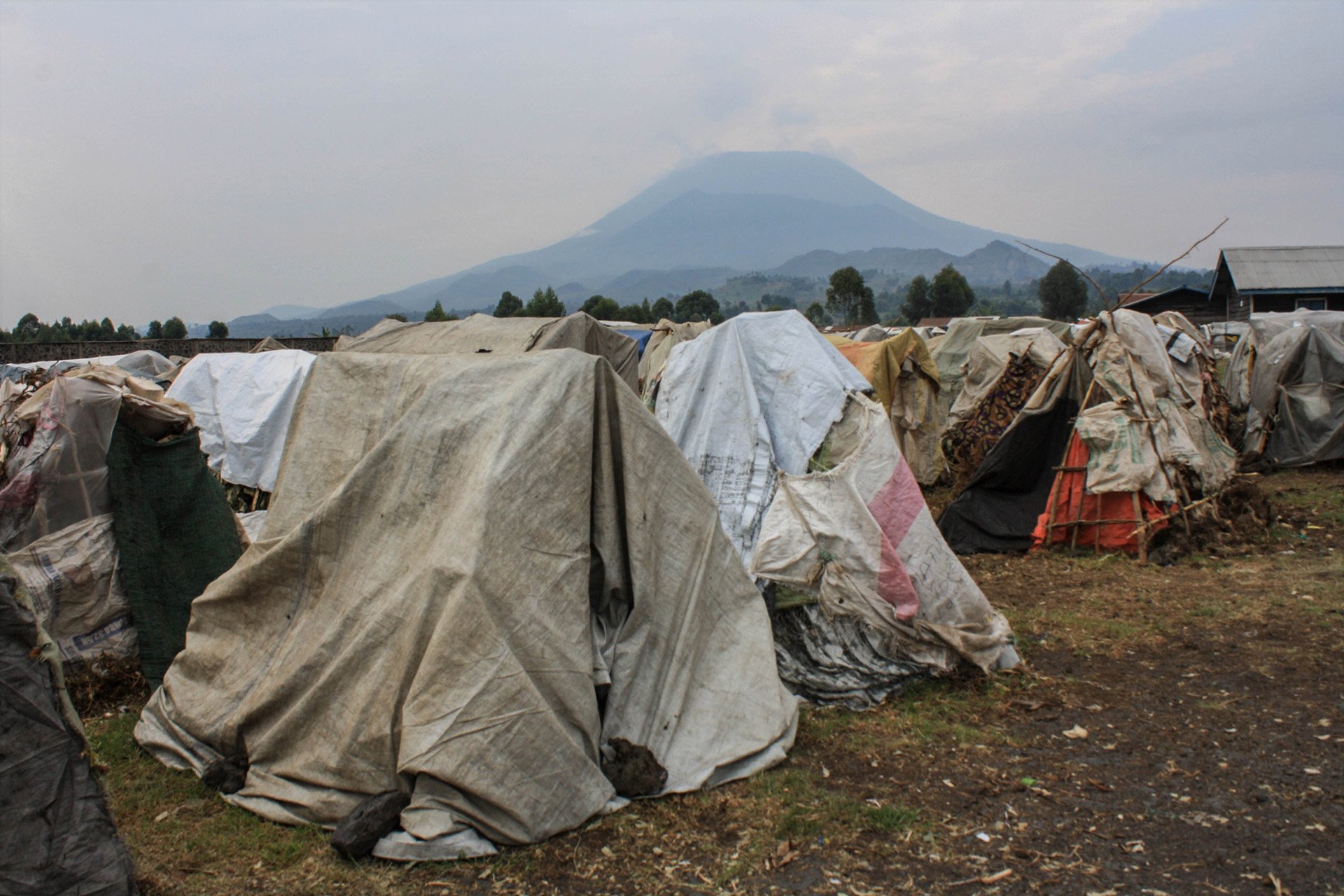 The photo shows several tents made from scraps of fabric 