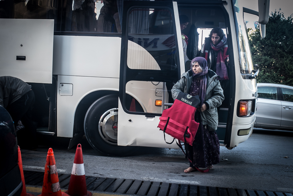 Refugees disembark from a bus after having been intercepted by coastguards and returned to Izmir