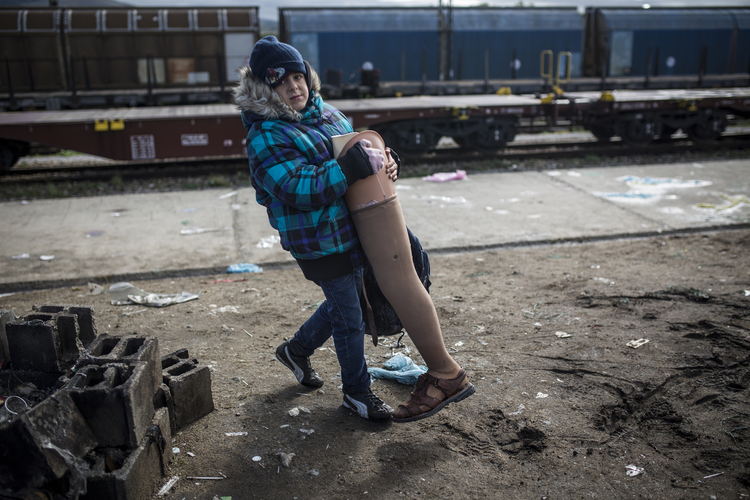 Child carries his grandfather's prosthetic leg