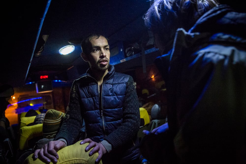 Shafiullah Muzaffar, 23, helps a German volunteer to communicate with the other Afghan refugees