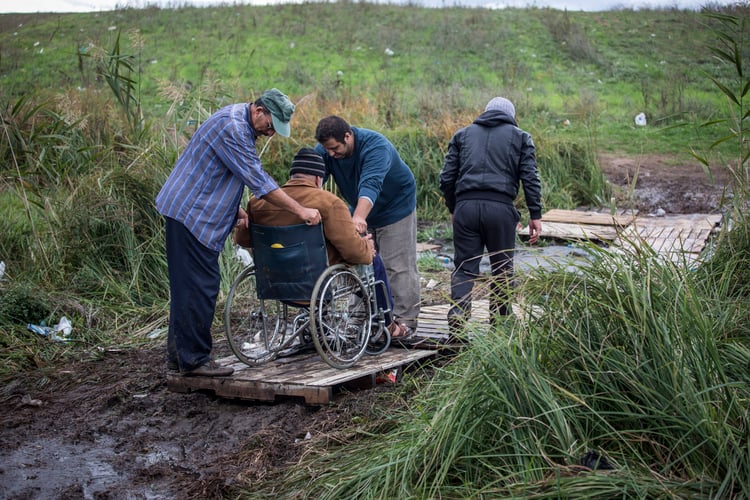 Disabled man being transfered to his wheelchair