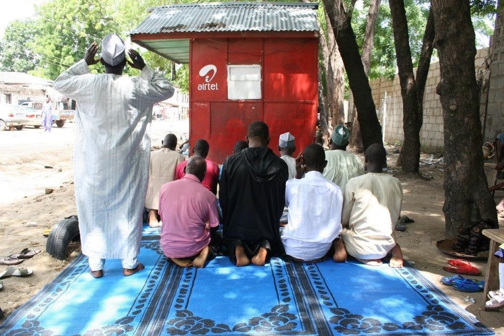 Men in Nigeria pray outside