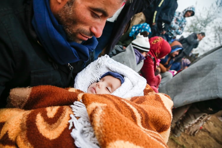 A man keeps his baby warm