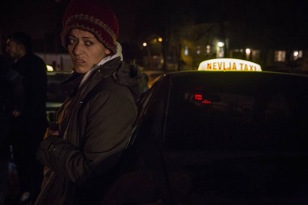 A Syrian woman arrives by taxi with other Syrian refugees at the registration centre in Dimitrovgrad. Taxi drivers often pick up migrants who arrive on the outskirts of town or in nearby villages, charging them exorbitant rates for the short journey, acco