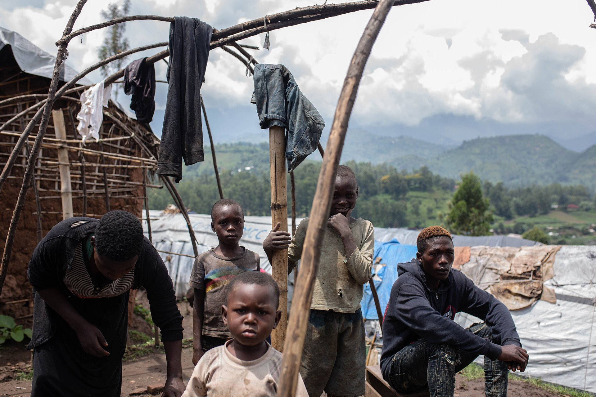 A family of internally displaced people build a new shelter at a camp in Minova