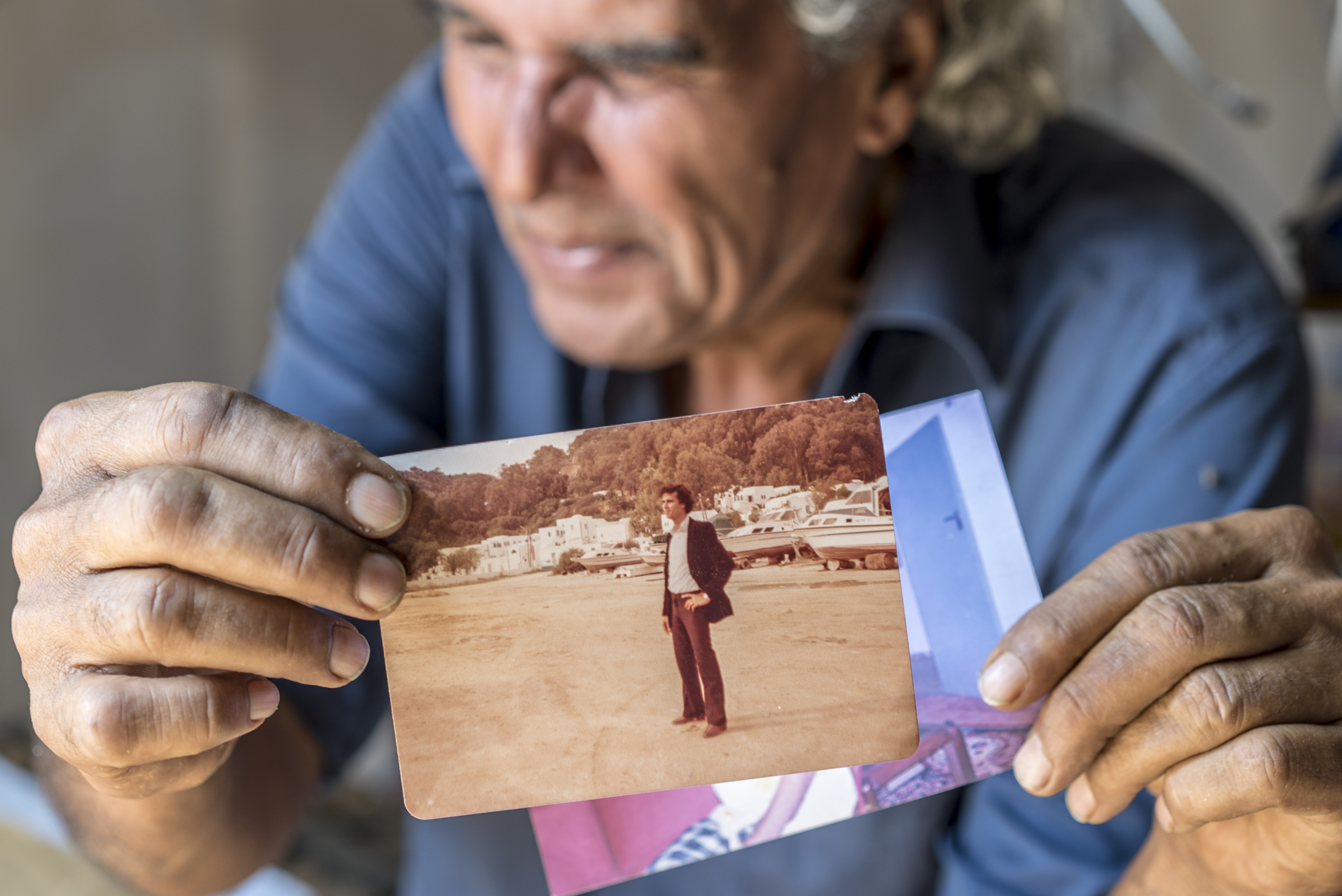 A man holds up a photo of life in Aden, during better times, long before the war