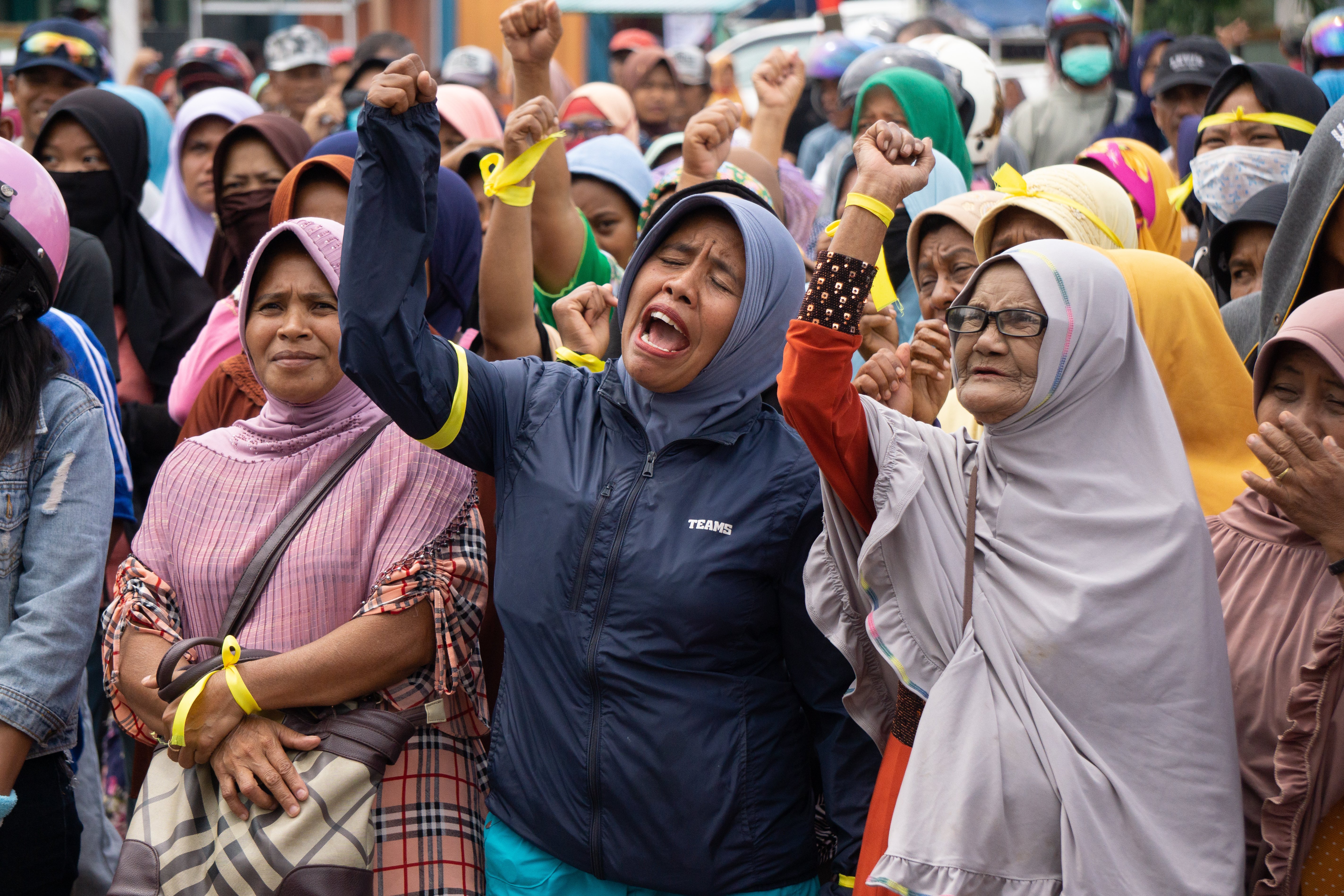 Demonstrators chant to demand the government listen to their concerns about being relocated and rebuilding their homes.