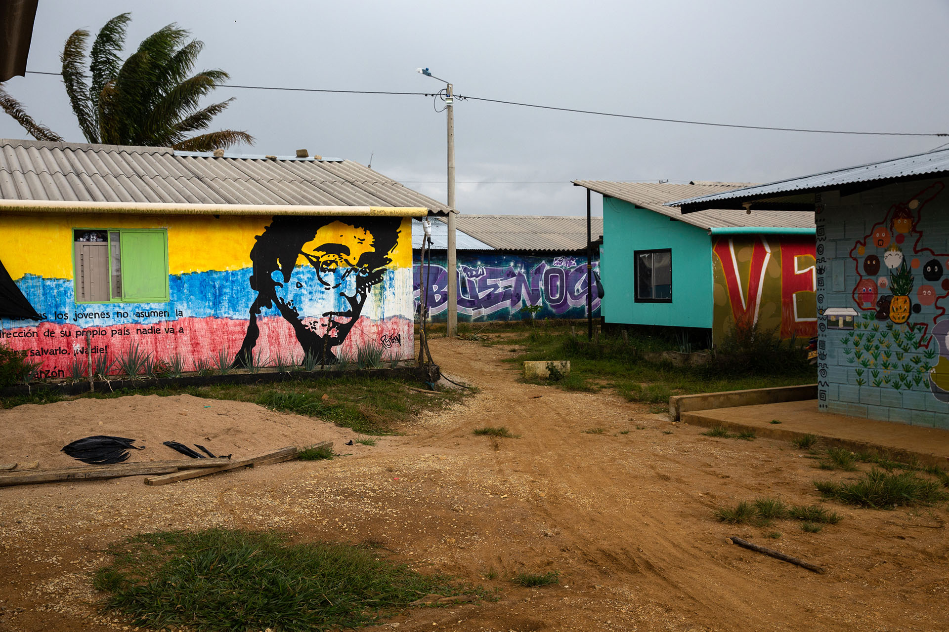 Political murals cover the community. At left appears a portrait of slain journalist and Colombian leftist icon Jaime Garzon.