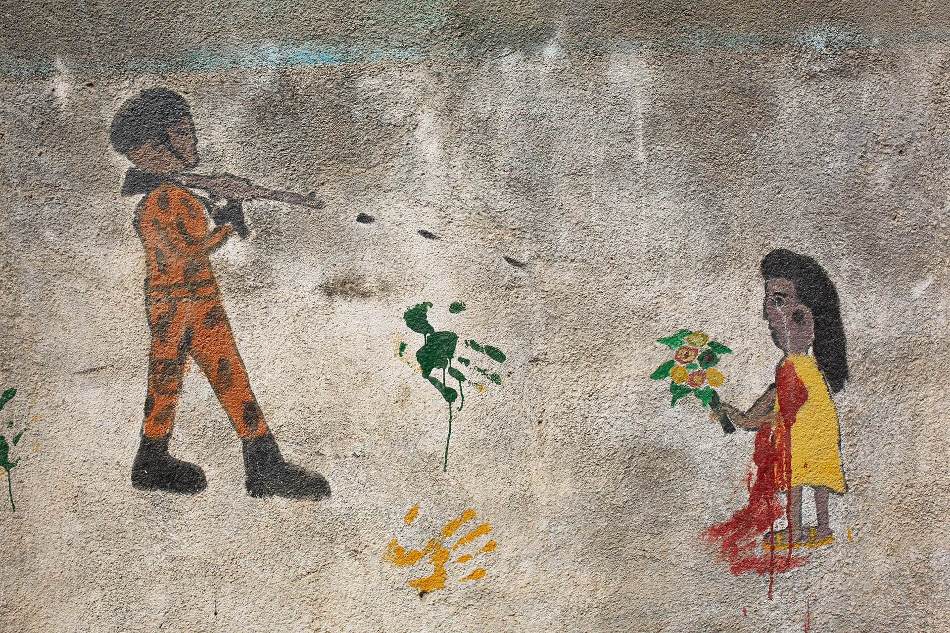 Graffiti shows a soldier shooting a civilian on a wall. 