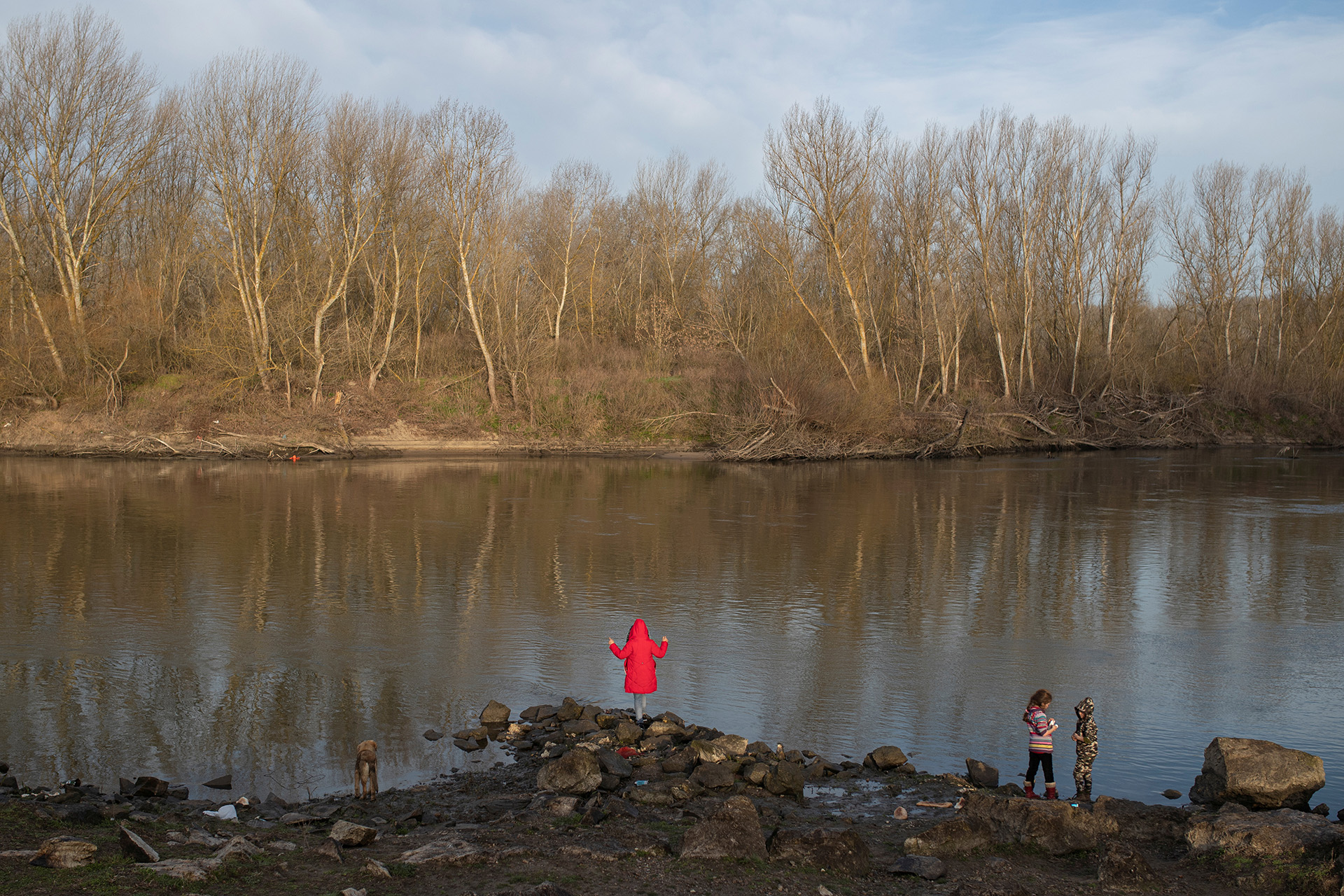 Migrants stand on the banks on the Turkey side of Evros River