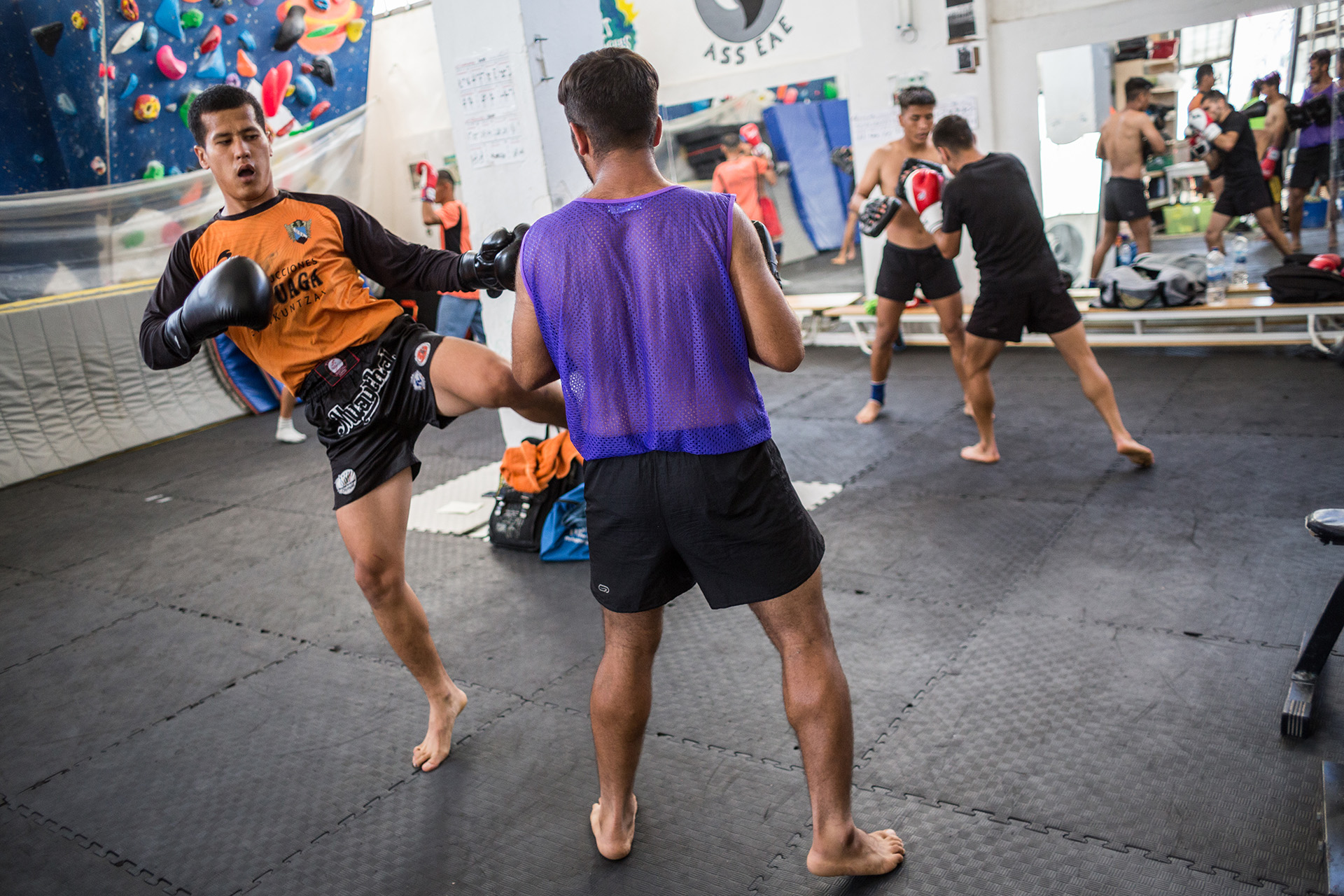 Mahdi Khavari, a 28-year-old Afghan, teaches Muay Thai for Yoga and Sport with Refugees every afternoon in the association's gym. In this photo, he is kicking during a sparring session.