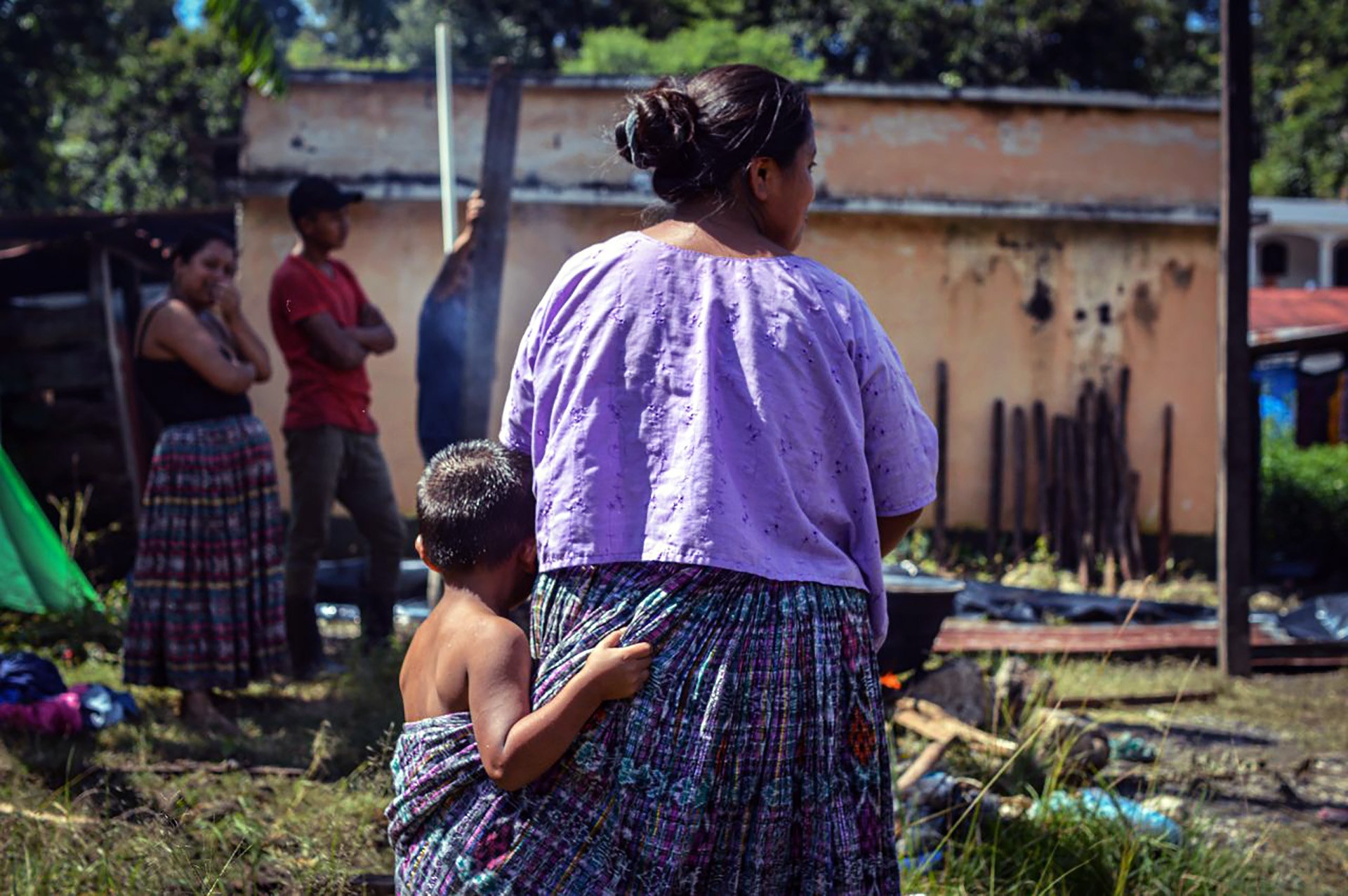 A woman from the village of Quejá in the Alta Verapaz department bathes her son in water left behind by Eta outside the shelter where they found refuge