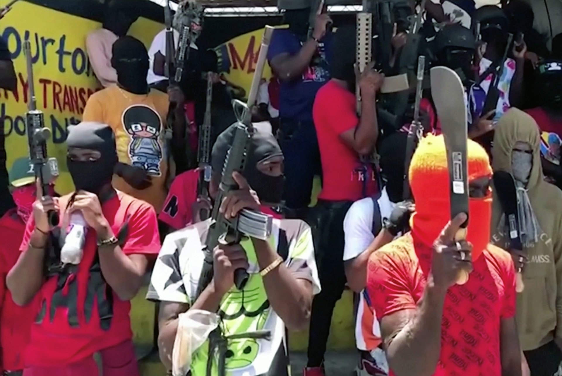 Gang members wielding machetes and guns stand in formation in Port-au-Prince, Haiti on 23 June, 2021, in this screen grab taken from a video.