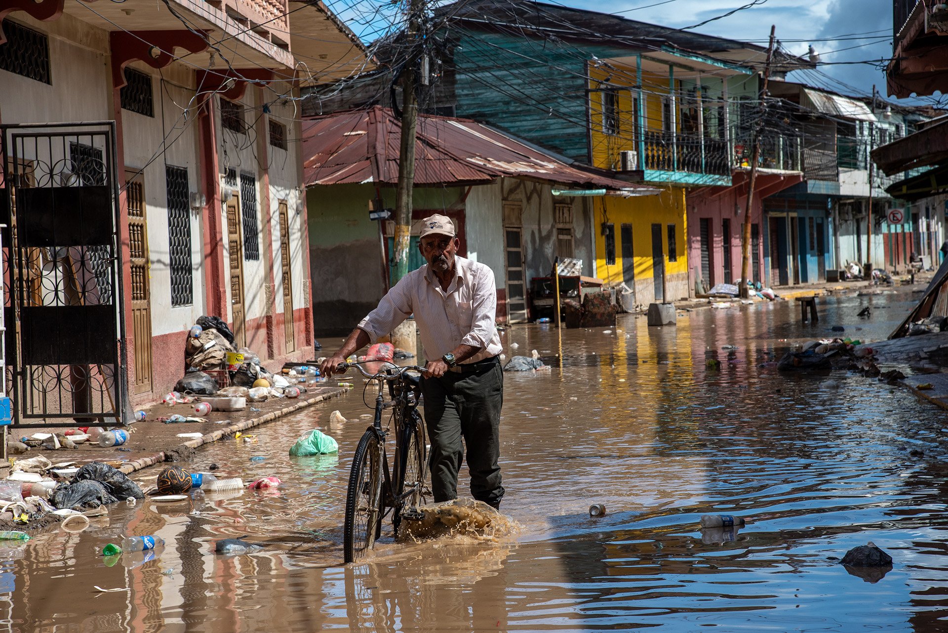 An elderly man walks his bicycle through the flooded streets of La Lima, Honduras after Hurricane Iota hit the region causing massive floods.