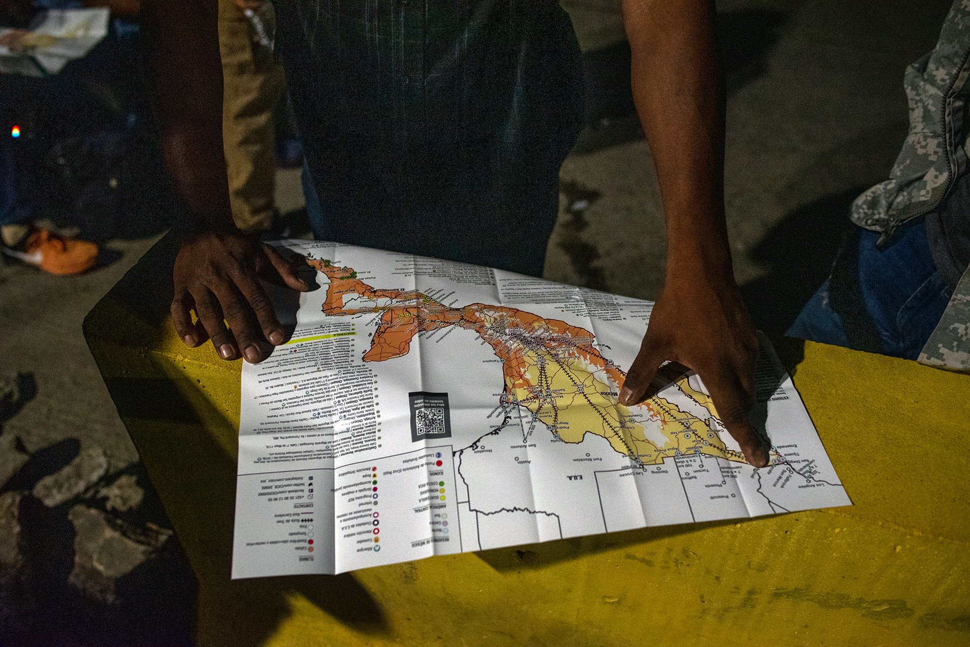 A Honduran migrant points to Tijuana, Mexico on a map – where he hopes to cross the border into the United States.