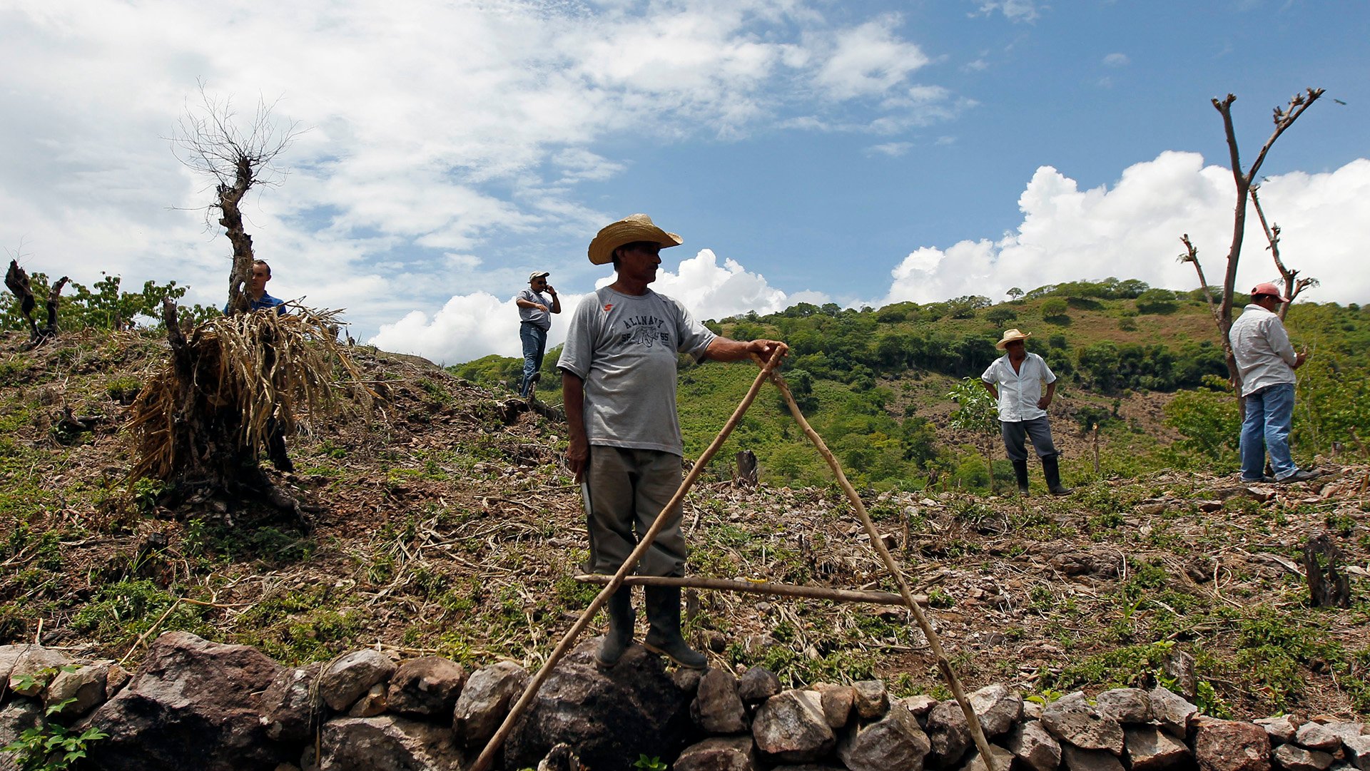 Farmers wait during a distribution of food aid to families affected by the drought in the village of Orocuina, Honduras