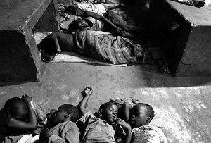 [Uganda] Young children sleeping on the ground at the bus park in Gulu.