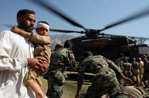 [Pakistan] Muzaffarabad, Pakistan, A father carries his injured son from a German SAR helicopter after they where taken from their devastated village. [Date picture taken: 10/13/2005]