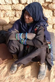 [Niger] A slave girl in north west Niger. “I was born into slavery, my parents are also slaves. We are worked so hard, I have come, by donkey, to Ayorou (town in Tillaberi region) to buy millet for my master who sent me.” She wears a bracelet on her a