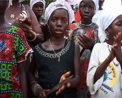 [Sierra Leone] A girl with the knife in her hands in an initiation ceremony. She will be taught to became a ‘sowie’ assistant. The custom provides an income to the women who perform the circumcisions.