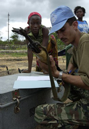 A UN peacekeeper inspects a weapon surrendered. As a result of the Disarmament, Demobilization, Rehabilitation and Reintegration (DDRR) programme, more than 100,000 combatants were disarmed and demobilized, including 22,000 women, 8,500 boys and 2,500 gir