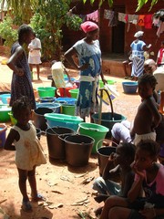 [Guinea-Bissau] Women and children fill up buckets from a street tap in the poor Bairro Militar district of Bissau, worst hit by cholera in 2005. [Date picture taken: 05/29/2006]