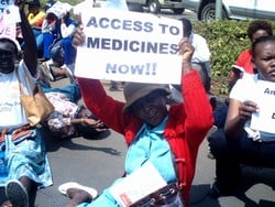 [Kenya] A woman holding a banner in the city centre of Nairobi protests at a proposed amendment that could increase the price of ARVs and other life-saving drugs, 25 July 2006. The demonstration was organised by the United Civil Society Coalition on HIV/A