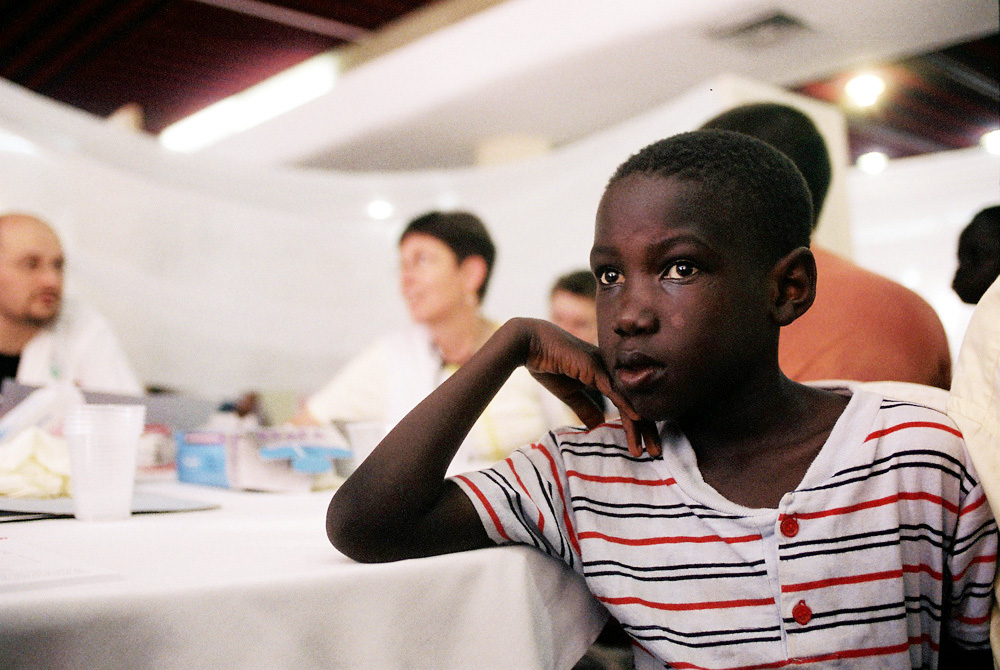 A refugee child from southern Sudan waits to see a volunteer doctor.