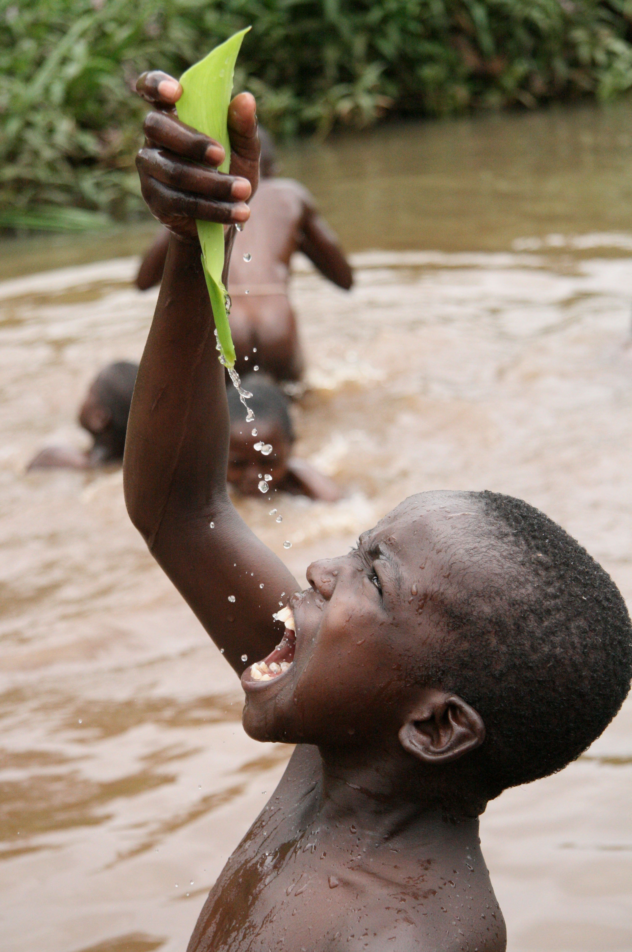 Children play and swim in pools of water that have formed after the rains in the Mathare slums, Kenya. March 2008.