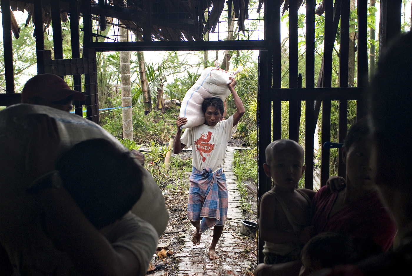 Residents of Kenna So Kyaung village, in the outskirts of Bogalay in the Irrawady delta region, receive rice from private donors.