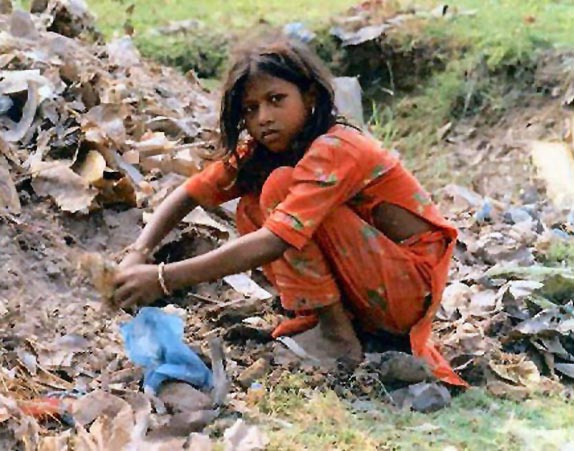 A girl picks through a garbage heap. The looming food crisis has added to the desperation of many impoverished families.