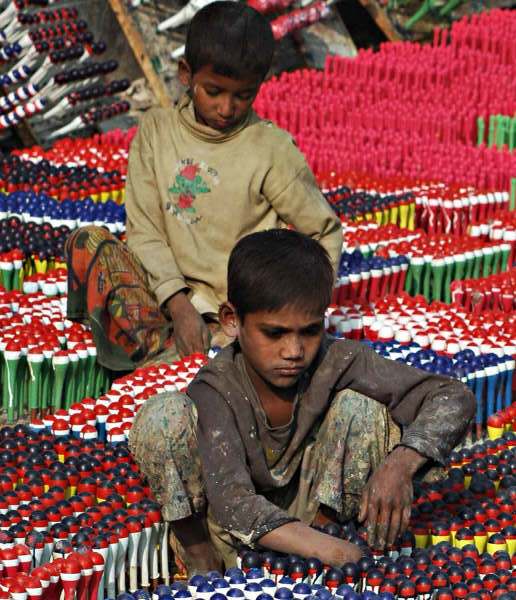 Children working at a balloon manufacturer's in the midst of highly combustive plastic powder