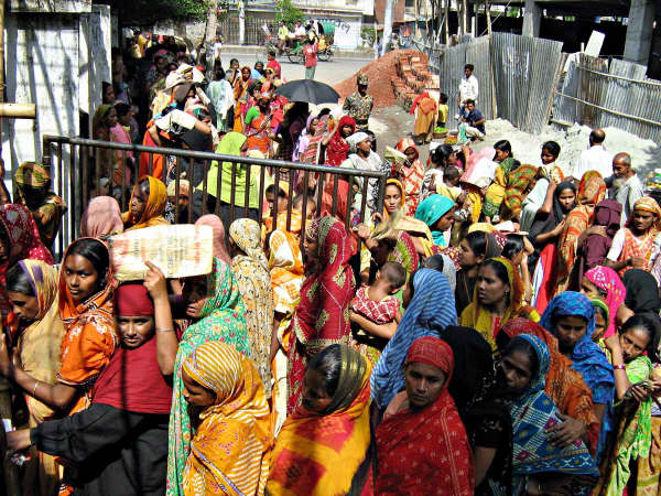 Each year river erosion lleaves thousands of people homeless. These people then throng the cities in search of jobs. Photo shows women waiting for cheap rice sold by the the government. Most of these people are climate change refugees from the southern di