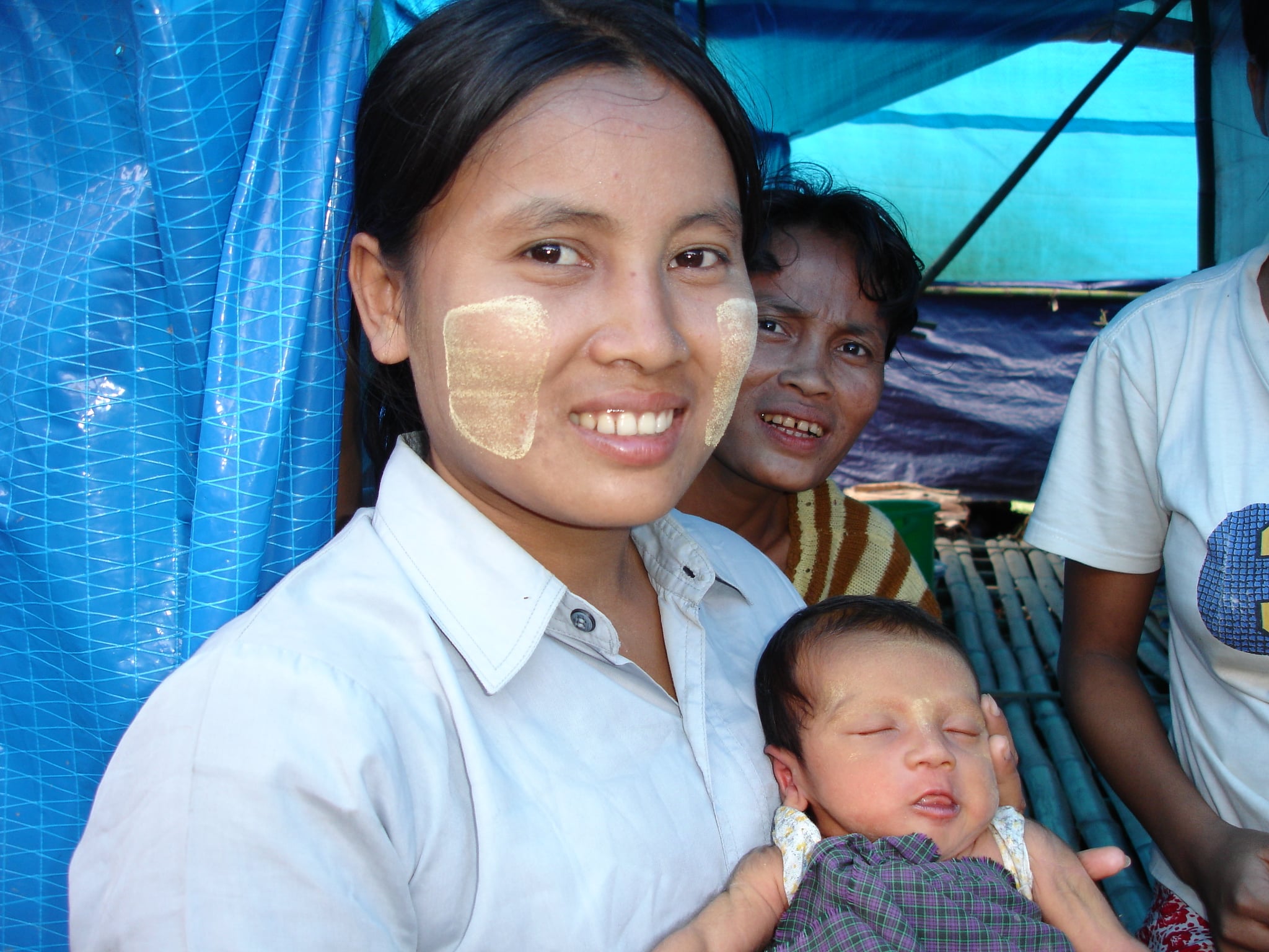 A young woman and her newborn baby at a displaced persons camp outside
