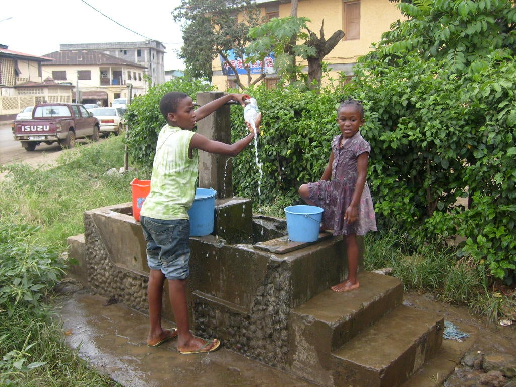 Two children wait at a public fountain in Malabo for water to arrive. UN estimates less than half of the population has access to clean drinking water.