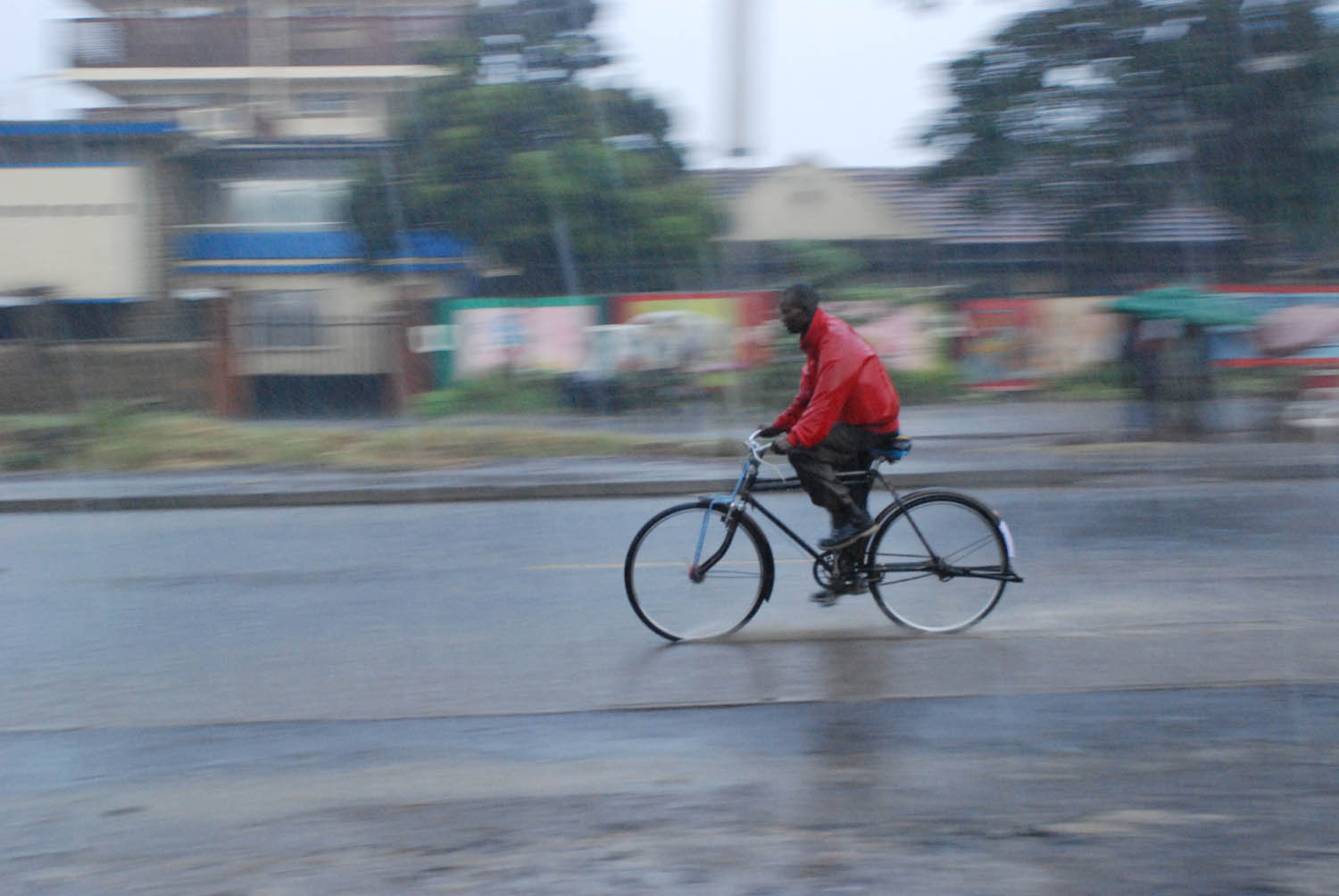 A man cycles home despite the heavy downpour in Nairobi, Kenya 2008. Areas such as Mandera have experiencing heavy rains which could be an effect of climate change.