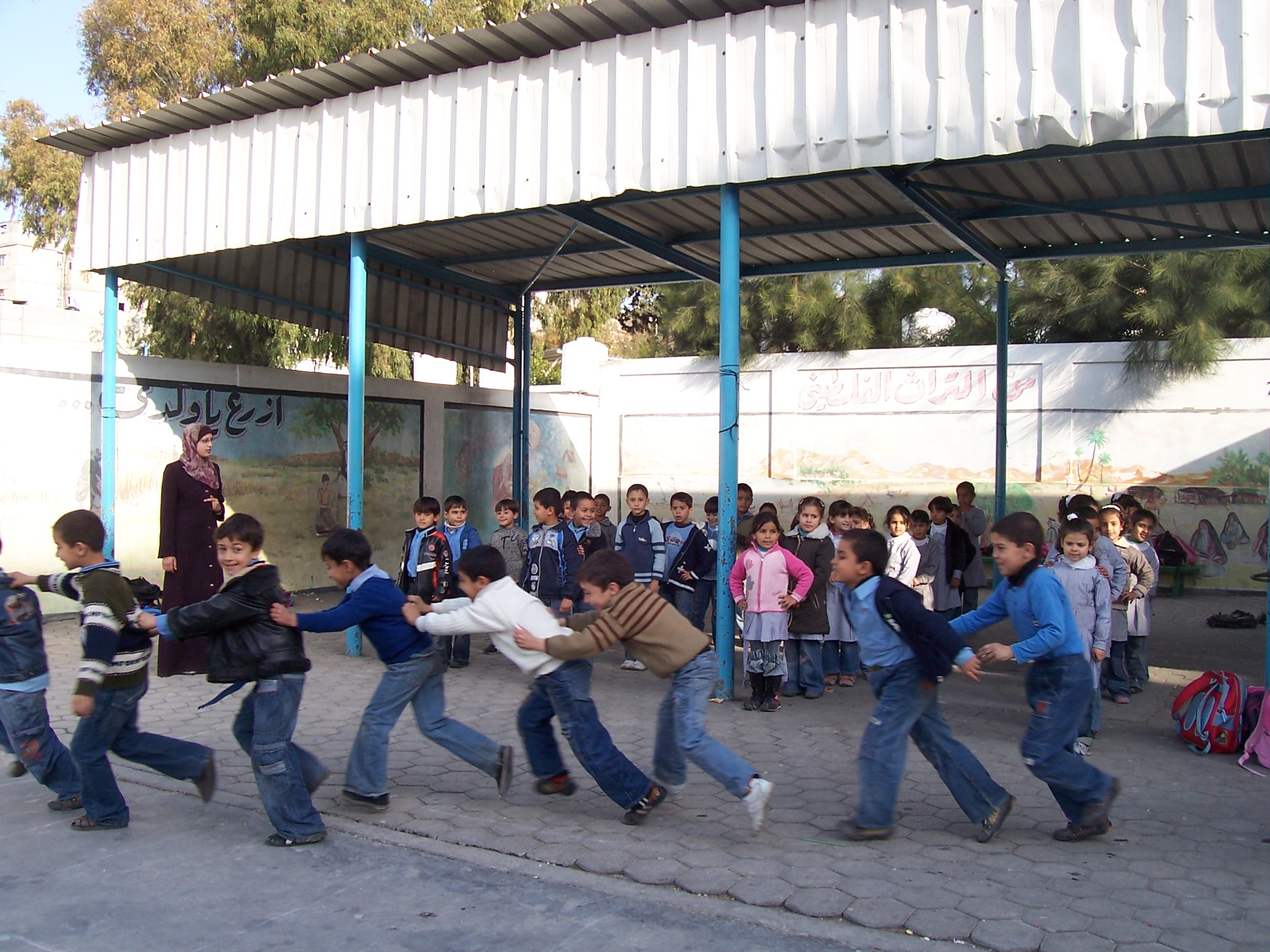 First graders at Asma Co-ed Elementary School “A&B” in Gaza City, run by UNRWA, participating in stress-relieving games and activities to recover from psychosocial trauma incurred during the war