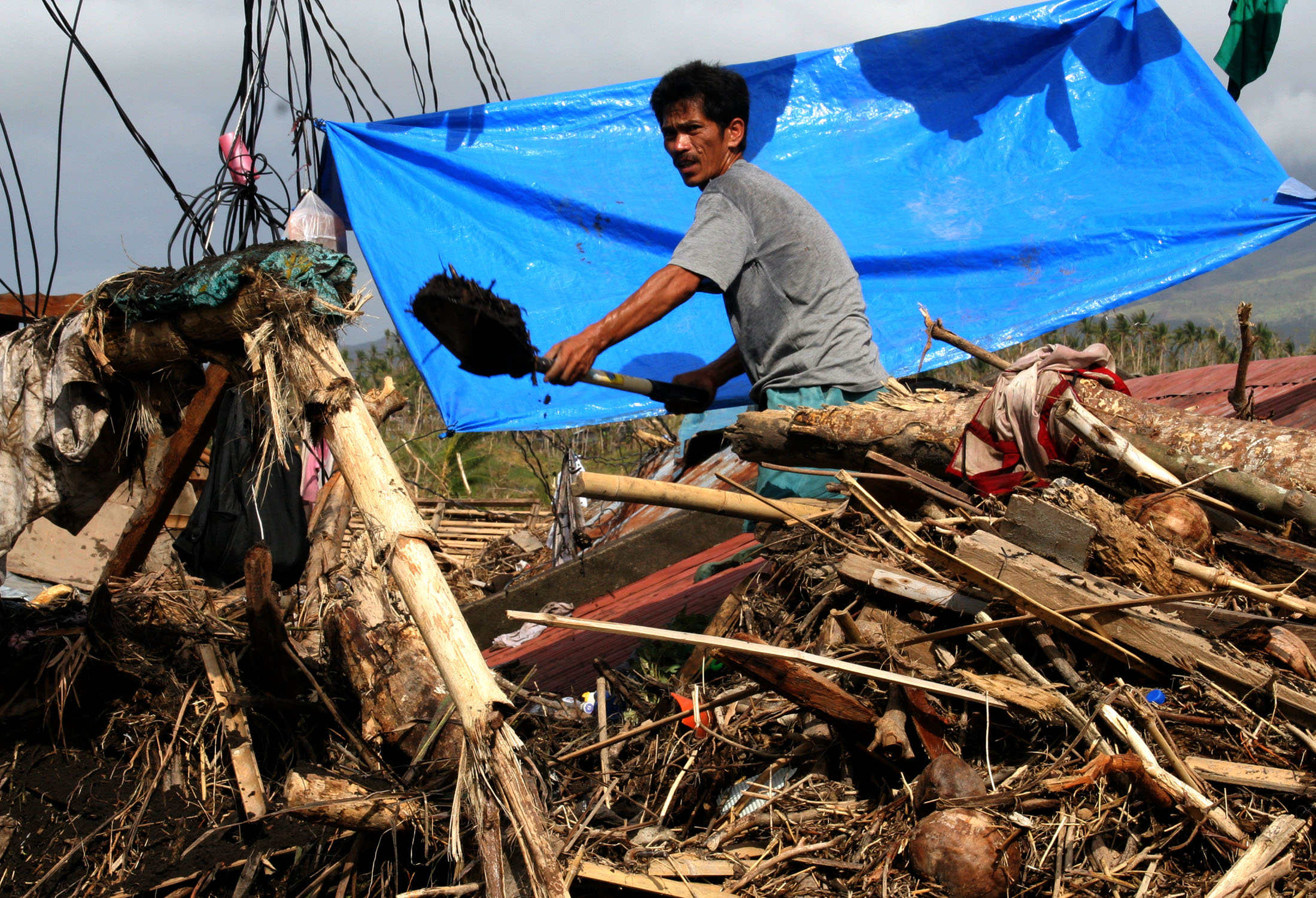 Daraga, Albay A man uses a shovel do dig his home buried by a