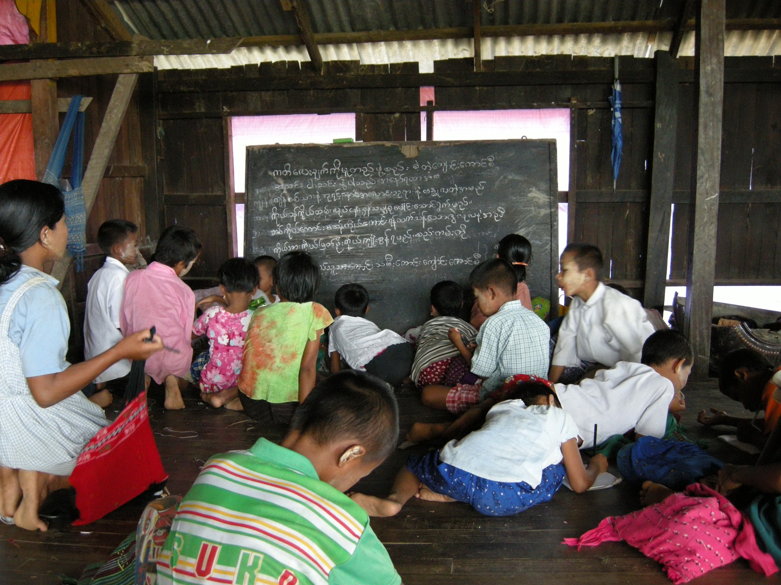 Primary school students learning on the floor of a damaged monastery in Gwe Gon village, Dedaye Township, Irrawaddy Delta