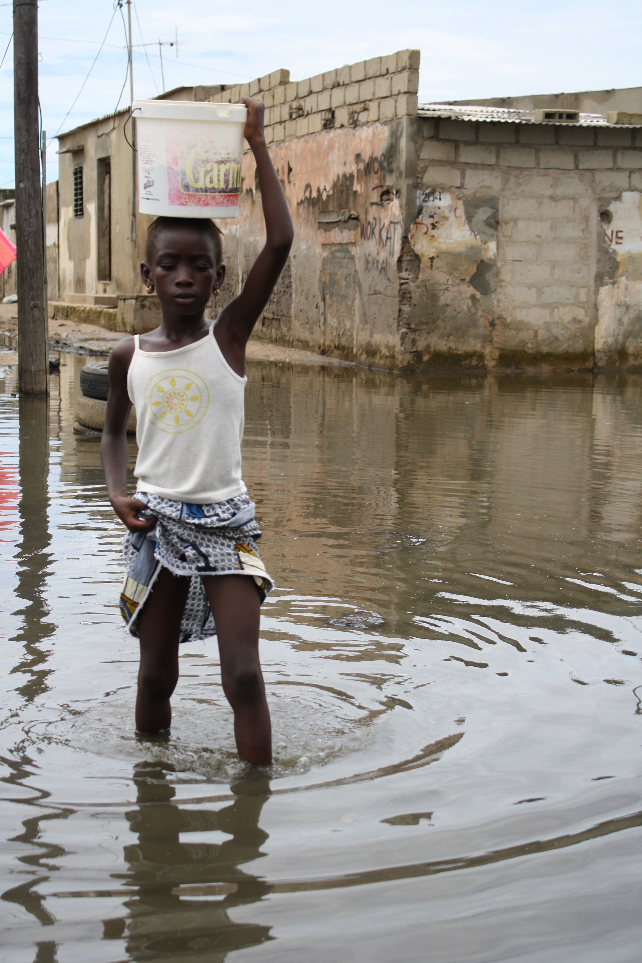 A girl walks across a flooded street in the Pikine neighbourhood of the Senegalese capital Dakar. August 2009