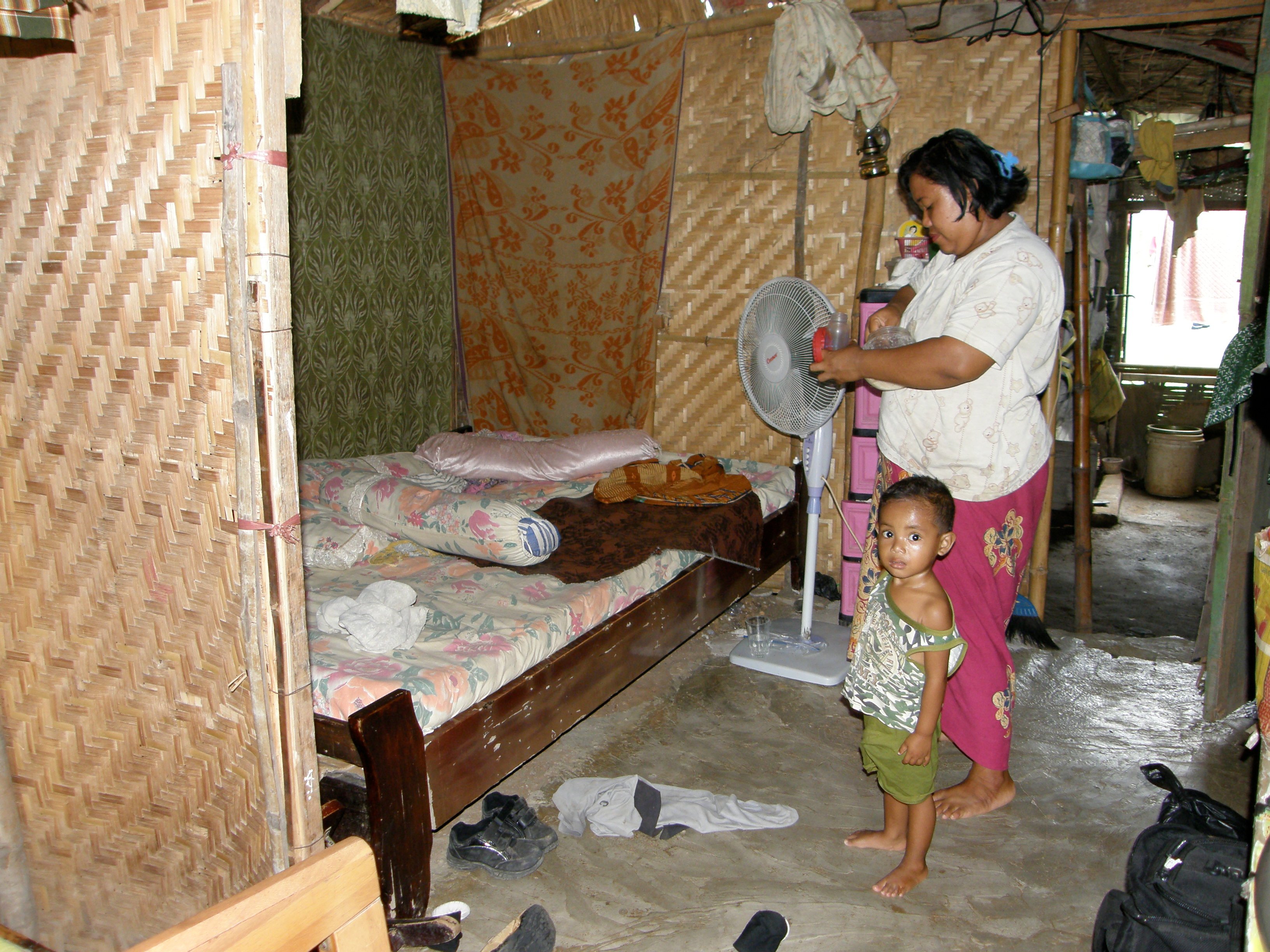 Siti Rochma in her family's one-room bamboo shelter in Besuki village, in the district of Sidoarjo in East Java Province, Indonesia