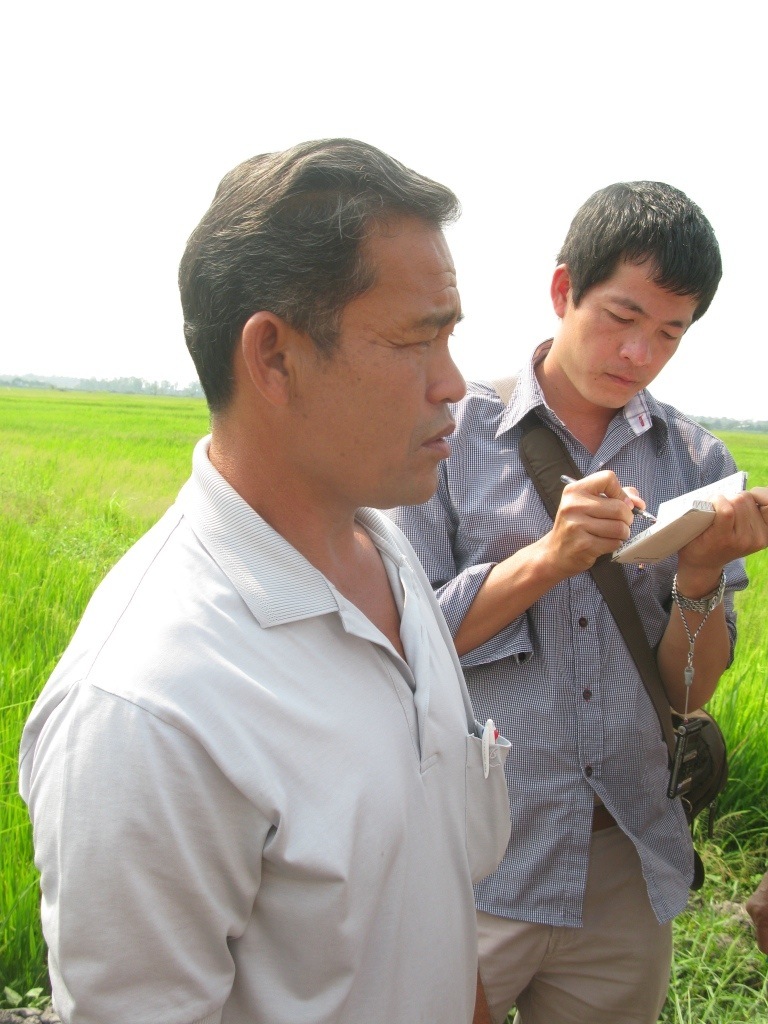 Farmer Bountieng Keomanyvong (foreground) is concerned about being relocated