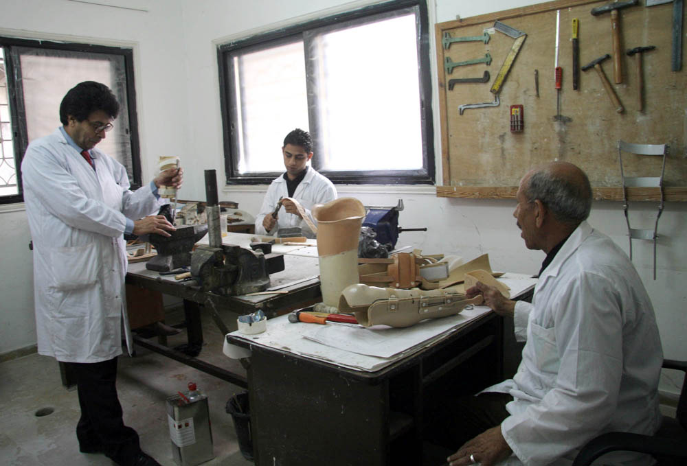 Mohammed Ziada (left), a specialist at the Artificial Limb and Polio Centre, and his colleagues make artificial limbs for amputees