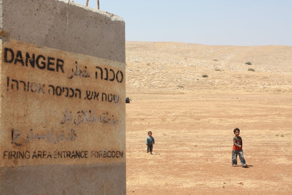 Bedouin children wander away from their home in al-Hadidiya village in the West Bank, which is now within a closed military zone claimed by the Israeli army