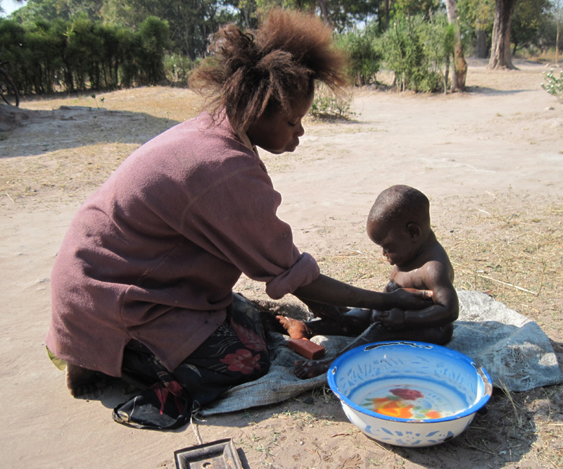 A young mother bathes her baby in Luapula Province, northern Zambia